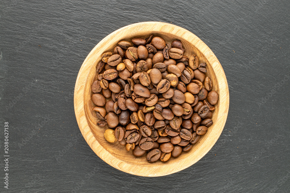 Fototapeta premium Roasted coffee beans on a slate stone. Top view.