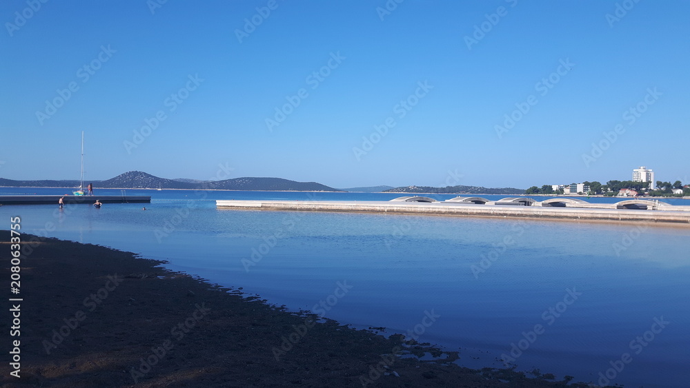 Fototapeta premium Seaside View with Pier and Sailboat in Vodice, Croatia