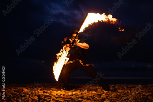 Fire performer with burning torches at night