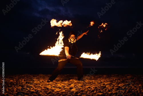 Fire performer with burning torches at night