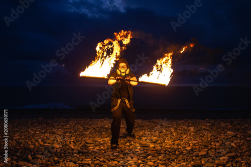 Fire performer with burning torches at night