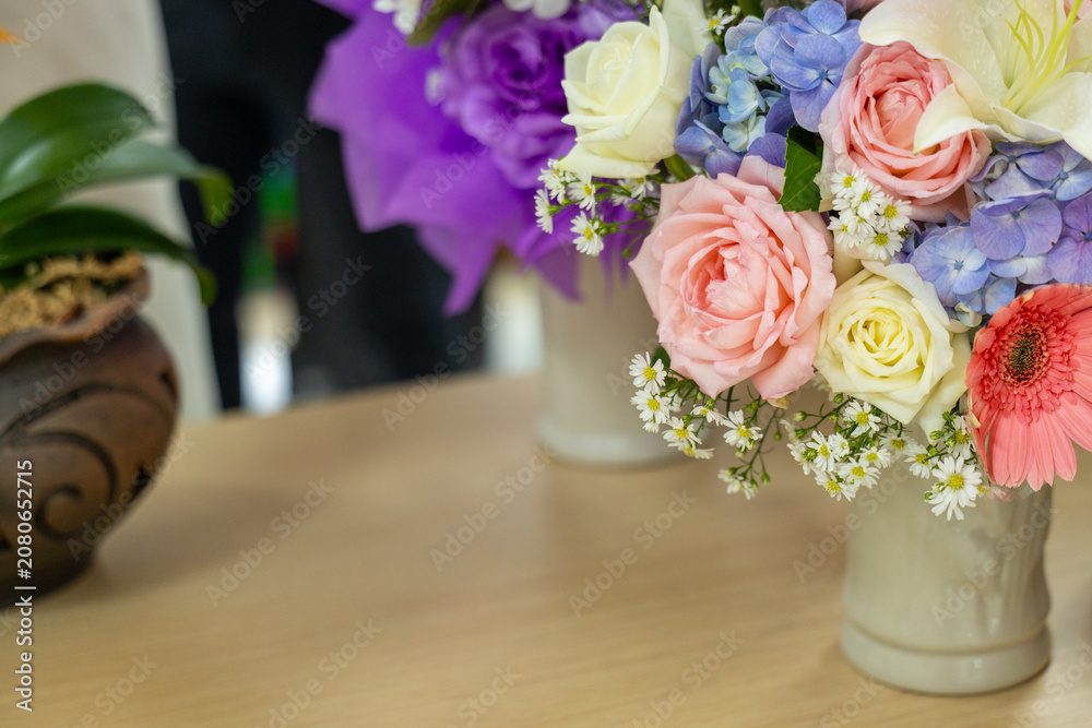 Obraz premium Colorful flower bouquet pink rose white rose purple hydrangea yellow rose daisy gerbera green leaf ceramic vase wooden table indoor natural light cheerful mood