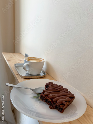Chocolate brownie with coffee on a cozy cafe table. Minimal coffee break lifestyle