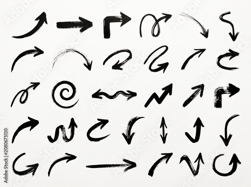 Various hand drawn black ink arrow shapes isolated on a clean white textured paper background