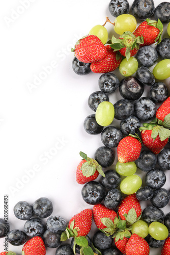 Fresh ripe Blueberry strawberry grape macro closeup on wood dark white background
