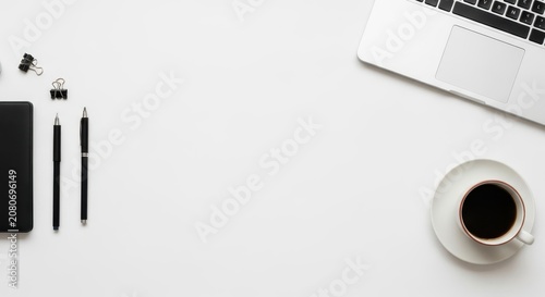 A minimalist modern white workspace featuring a clean laptop on a desk, ideal for productivity and remote work setups.