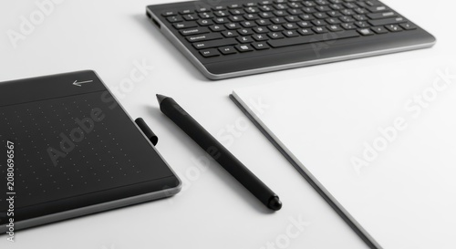 Modern creative workspace with digital tablet, stylus, and keyboard on a clean desk.
