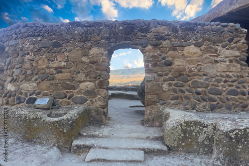 Canvastavla Old doorway in ancient stone wall on sunset sky background