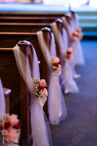 фотографія Floral and fabric arrangement on church pew for wedding ceremony