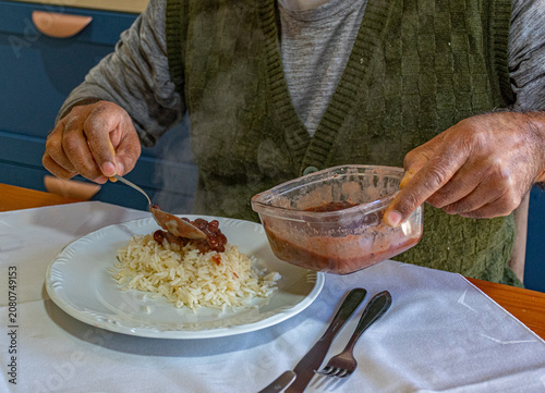 Fotografie pessoa colocando no prato arroz e feijão