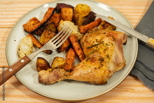 Canvas Print Roasted chicken leg and root vegetables dinner plate