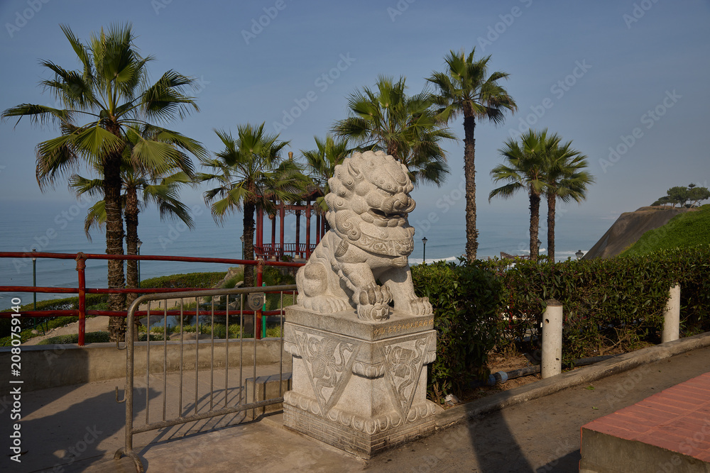 Fototapeta premium Intricately carved dragon sculpture is a striking feature of the Parque Chino (Chinese Park) in Miraflores, serving as a powerful symbol of strength and good fortune. Perched along the cliffs of the M