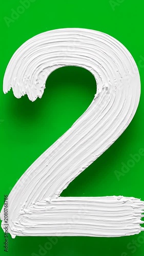 White textured number two on green background.