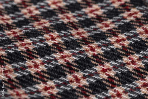 Close-Up Diagonal Plaid Wool Fabric Texture in Black, Red and Beige Tones