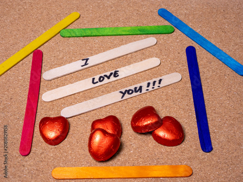 Three of the plain wooden sticks in the center are arranged horizontally, with the handwritten message 