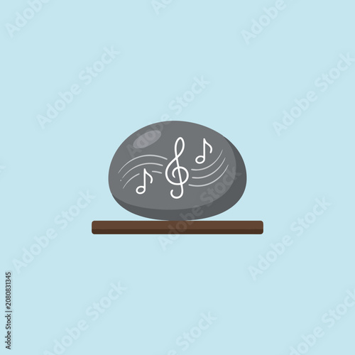 A smooth grey stone with musical notes on a wooden shelf
