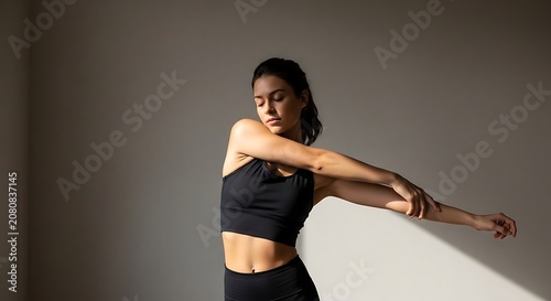 Woman practicing yoga in a modern studio with pink walls.