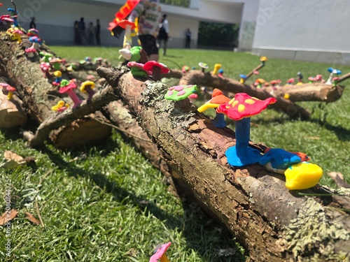 Fotografie Colorful handmade clay mushrooms decorating tree branches during an outdoor children's art activity
