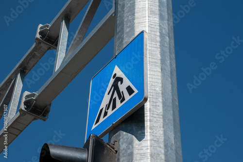 Fotografie A pedestrian crossing sign featuring a walking figure on a blue background
