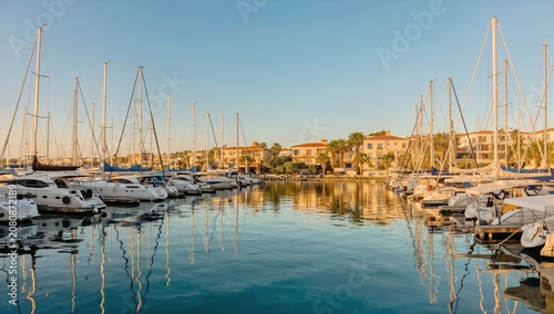 Reflection of Boats in Harbor With Clear Sky at Sunset Near Coastal Village