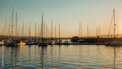 Sailboats Docked at Harbor During Sunset With Calm Waters in the Background