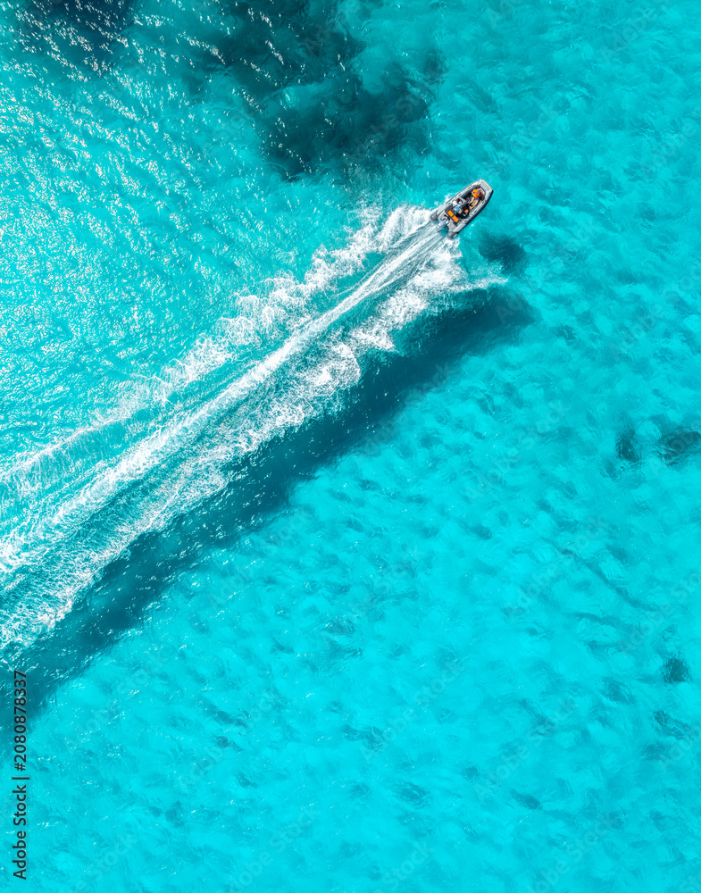 Naklejka premium Aerial drone view of floating speed boat in blue sea on sunny day. Summer vacation. Mallorca island, Spain. Top down view of boat, sea, turquoise water. Travel. Tropical landscape. Yachting. Cruise