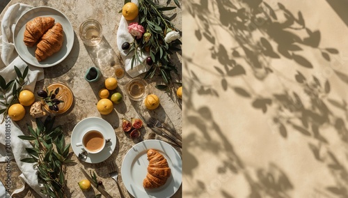 Morning Meal With Coffee, Croissants, Fruits, and Greenery on a Table in Sunl...