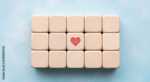 Wooden cubes with one red heart on a light blue background
