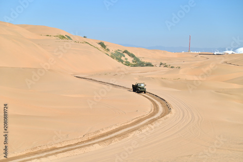 Off-Road Truck Moving Through the Vast Desert Landscape of Xiangshawan in Inner Mongolia
