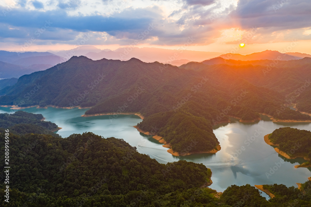 Naklejka premium Sunset Over Mountain Lake and Forested Hills