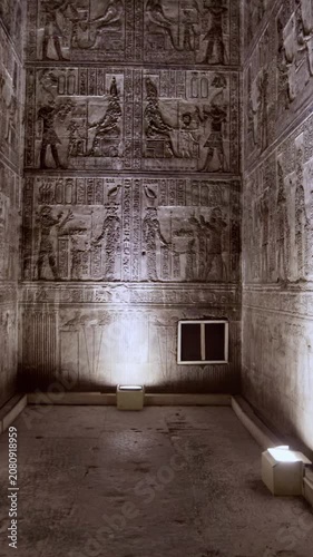 Dendera temple interior sanctuary with illuminated hieroglyphic walls and ritual