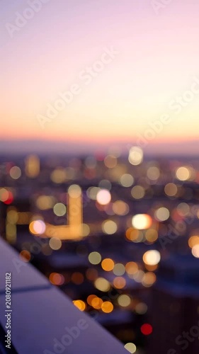 Stunning Urban Landscape at Dusk: A Blurred View from a Rooftop Overlooking the City, Capturing the Vibrant Colors of Evening Lights and the Tranquil Atmosphere of Twilight.