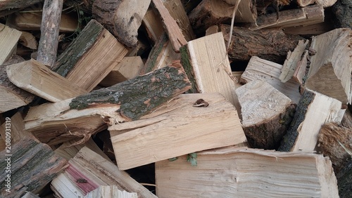 Close up of chopped firewood logs with bark natural wood texture