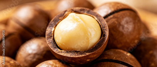 Foto Open Macadamia Nut with Whole Nuts Background