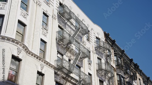 Iconic fire escapes on brownstones and pre war architectural details of a historic New York City building facade creating a classic Manhattan street scene