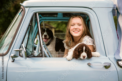 young woman in truck with dogs