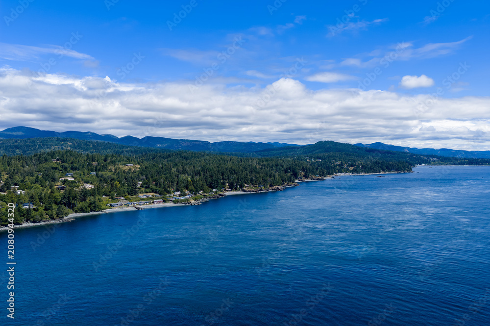 Naklejka premium Pacific Coastline View Over Forested Shoreline and Blue Ocean at Otter Point, Sooke, Vancouver Island