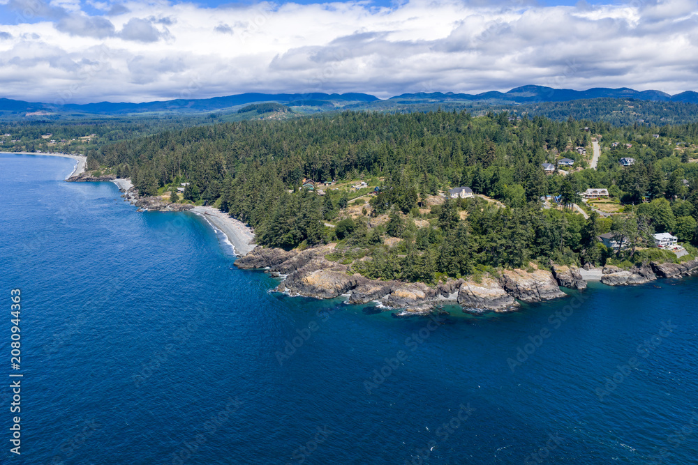 Fototapeta premium Aerial View of Rocky Coastline and Evergreen Forest at Otter Point, Sooke on Vancouver Island