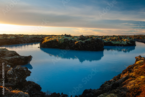 Volcanic lava formations beside the Blue Lagoon in Iceland with vivid moss colorful geothermal landscape and crystal blue water