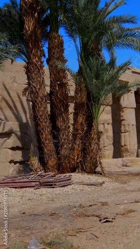 Seti I mortuary temple exterior with Osiride colonnade and palm trees in Luxor