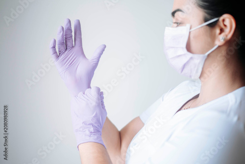 Canvas Print Healthcare professional putting on sterile gloves before attending a patient in a medical clinic
