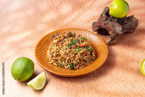 Thai-Style Stir-Fried Rice with Lime on Rustic Background