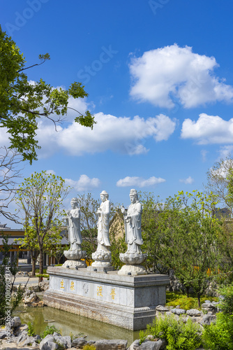 Three White Buddhist Statues in a Serene Chinese Garden