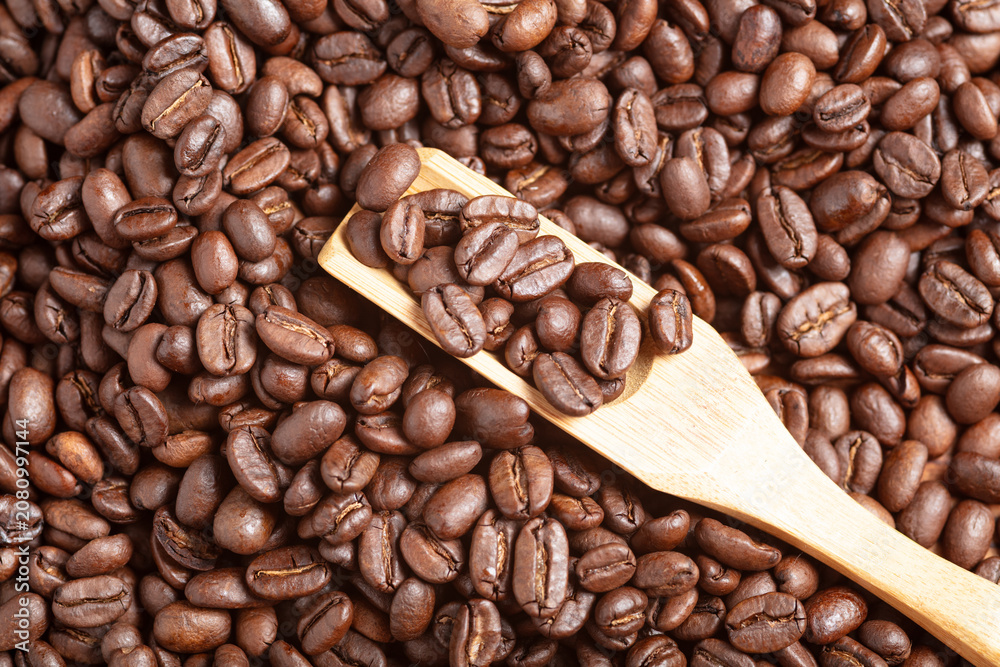 Fototapeta premium Roasted Coffee Beans with Wooden Scoop Background