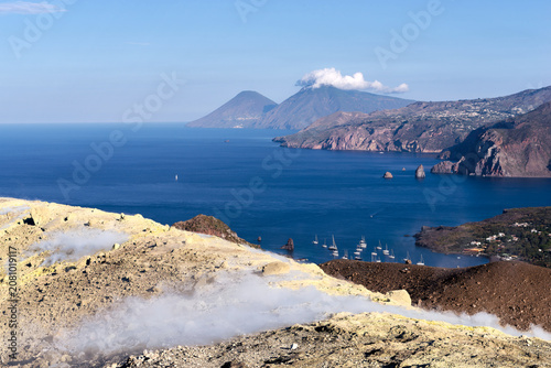 View from Vulcano island crater with smoking sulfur fumaroles looking towards Lipari and Salina Italy
