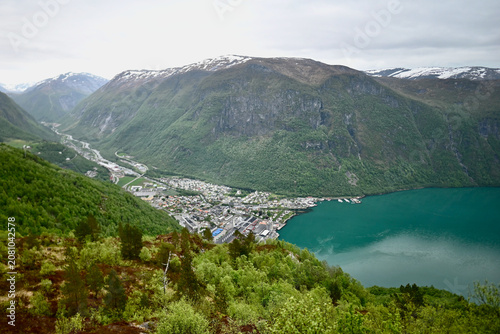 Panoramic view of Høyanger, a small town in Norway, seen from above the fjord, showing the valley, turquoise water, and surrounding rocky mountains.