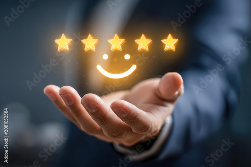 Businessman presenting glowing five-star rating and smiley face icon symbolizing excellent customer satisfaction and outstanding service quality in hand gesture