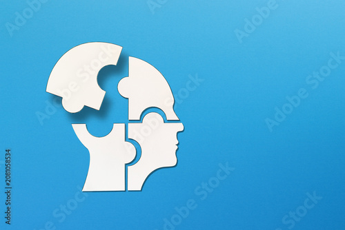 Mental health concept. Human head puzzle pieces on blue background.	