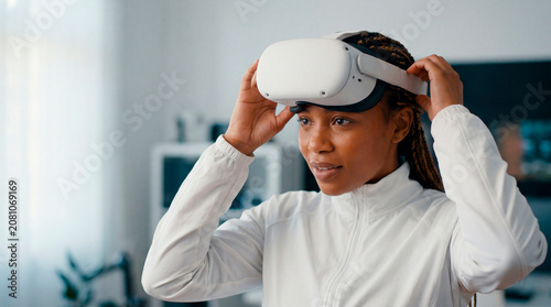 Young woman lifting virtual reality headset exploring immersive technology at home