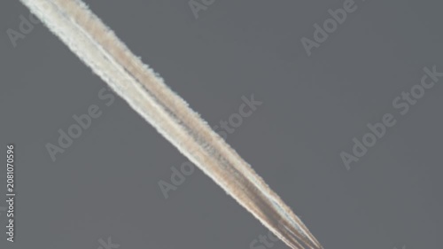 Close up of four engine aircraft with long sunset contrail